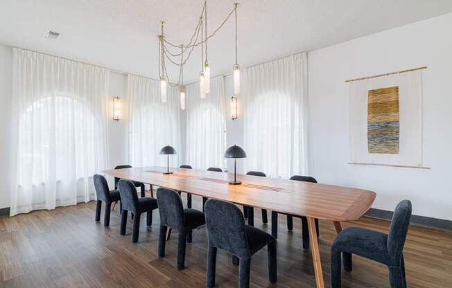 A dining room with a wooden table and black chairs.