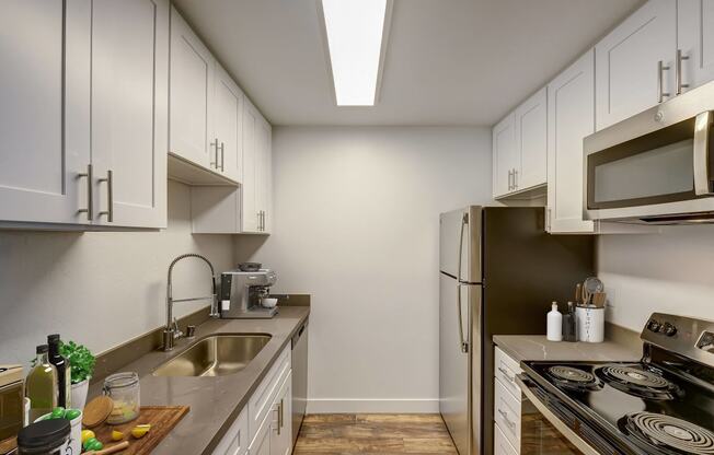 a kitchen with white cabinets and a stainless steel refrigerator