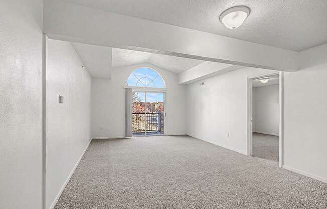 A spacious living room with a large window and a door leading to a balcony  at West Hampton Park Apartment Homes, Nebraska, 68022
