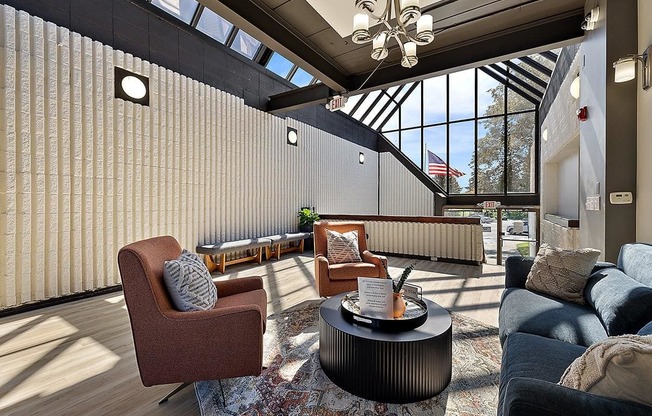 a living room with couches and chairs and a table at Troy Place Apartments - Troy, MI, Troy, Michigan