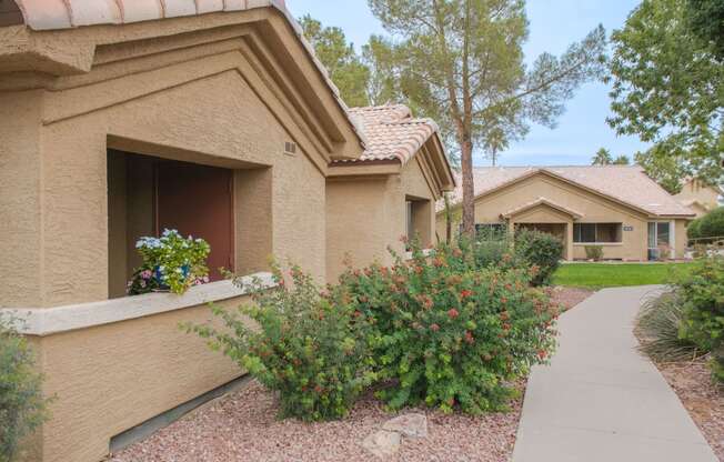 a house with a sidewalk in front of it and some flowers