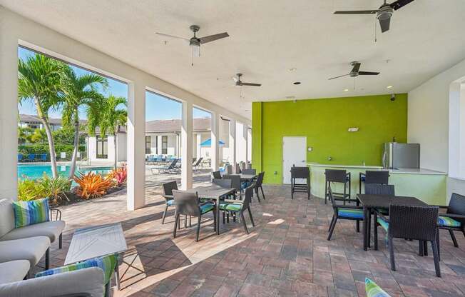 A patio with a table and chairs overlooking a pool.