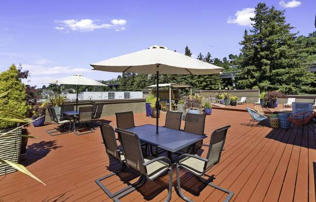 Rooftop wooden deck with tables and umbrellas at Illumina Apartment Homes, Seattle, Washington 98102