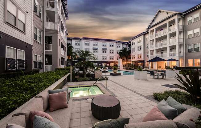 A modern outdoor seating area with a pool surrounded by residential buildings.