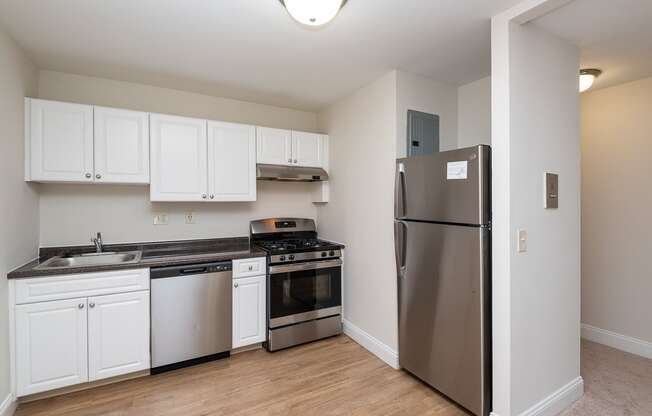 Quincy commons kitchen with white finishes, high quality flooring, and stainless steel appliances