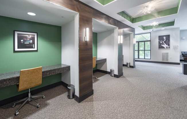 a hallway with a green wall and a desk with a chair at The Hendrix, Atlanta, GA