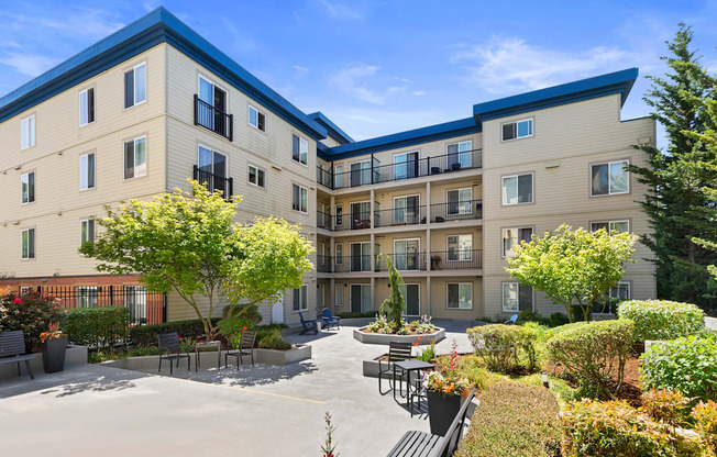 beautiful courtyard with paved area lined with plants and bushes at Guinevere Apartment Homes, Seattle, WA