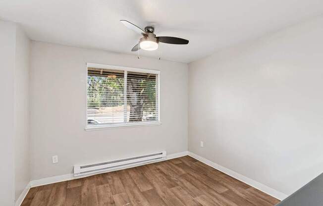 A room with a window and a ceiling fan.