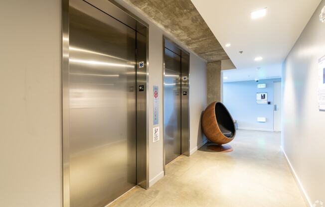 the lobby of a building with elevators and a chair