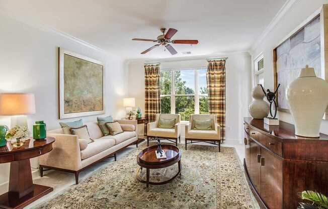 a living room filled with furniture and a ceiling fan