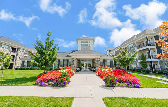a building with a sidewalk and colorful flowers in front of it