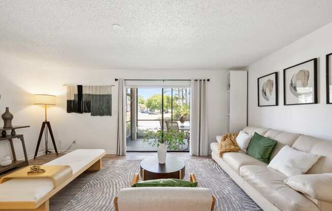 a living room with a white couch and a sliding glass door