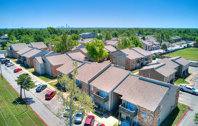 an aerial view of a row of houses with cars parked in a parking lot