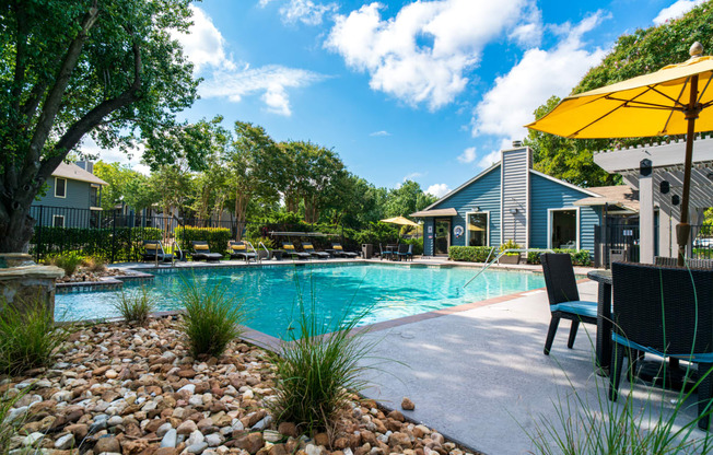 our apartments have a large swimming pool with chairs and umbrellas