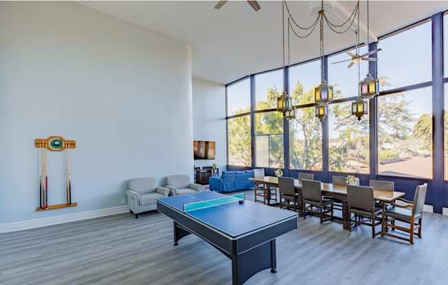 a living room with a ping pong table and a large window