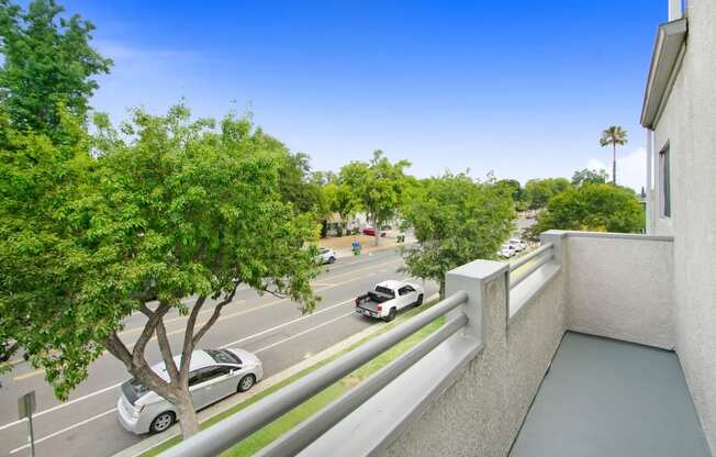 a view of a parking lot from a balcony with cars on the street