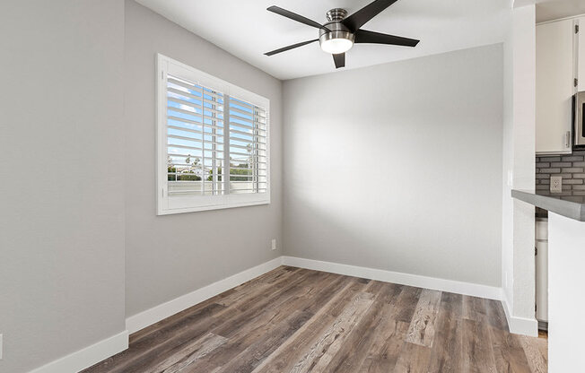 Hardwood floored dining room with ceiling fan.