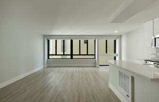 an empty living room and kitchen with a large window