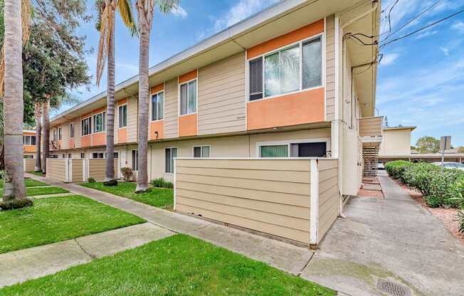 A row of houses with a green lawn in front.
