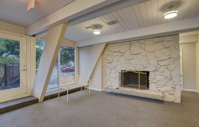 a living room with a stone fireplace and a window