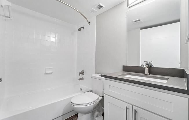 a white sink sitting under a mirror