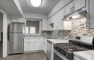 Kitchen at Mirador at Idlewood in Clarkston, GA, featuring energy-efficient appliances including refrigerator, gas stove, dishwasher, and garbage disposal; select units offer upgraded stainless steel finishes.