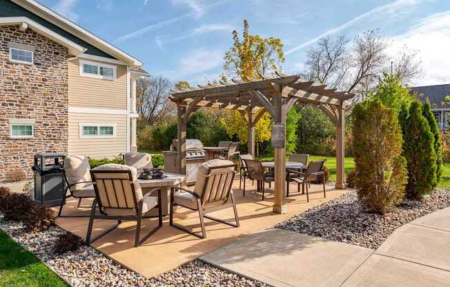 A patio with a table and chairs under a pergola.