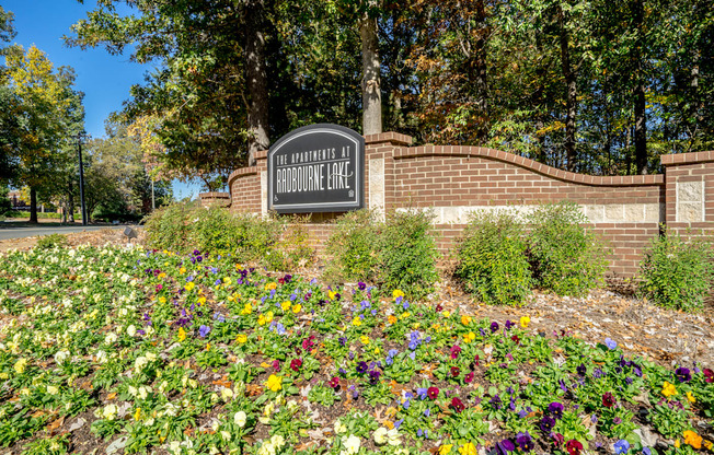 a sign in front of a brick wall with flowers at Radbourne Lake Apartments, Charlotte, NC 28269 ? 