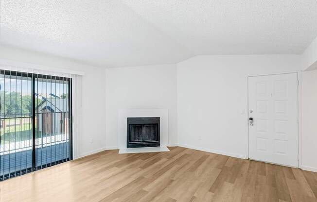 A room with a fireplace and a sliding glass door.