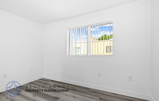 the living room of a house with white walls and a window