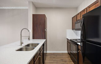 an empty kitchen with black appliances and a white counter top at The Fairways at Star Ranch, Texas