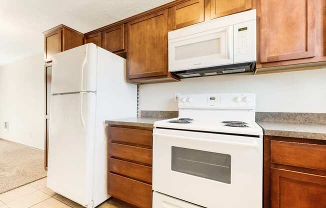 a kitchen with wooden cabinets and white appliances