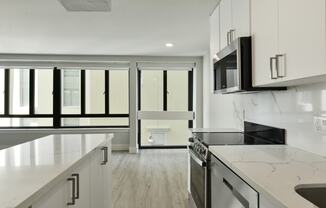 an open kitchen with marble counter tops and a large window