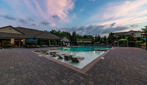 a swimming pool with lounge chairs in the middle of it at dusk at Echo at Lake Norman, Mooresville, 28117