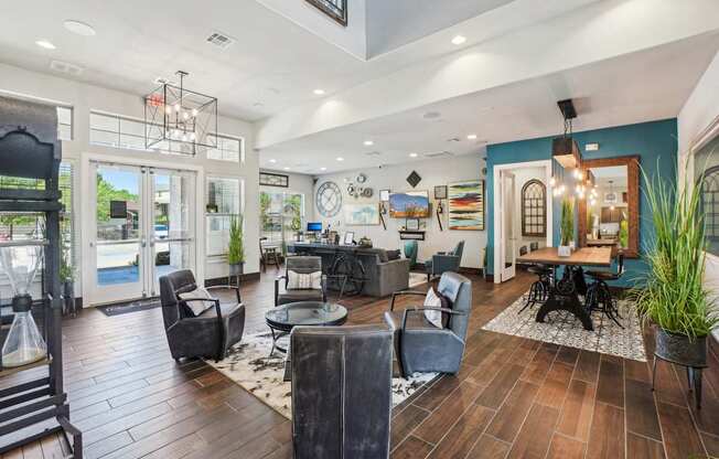 A large, well-lit living room with a variety of seating options and a wooden floor.