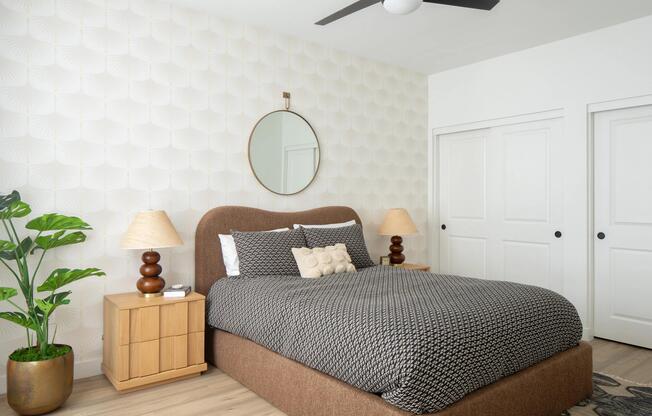 A calming bedroom retreat with textured wallpaper, warm wood tones, and layered neutrals for effortless comfort.