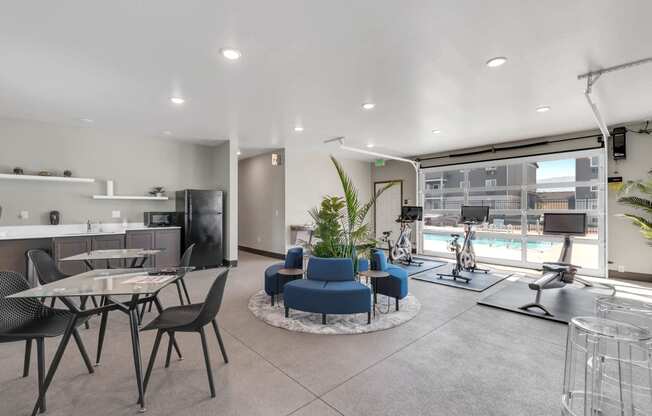 Spacious clubhouse with overhead doors and a pool view. A workout area to the right, and a kitchen and seating on the left. at Altitude, East Wenatchee, Washington