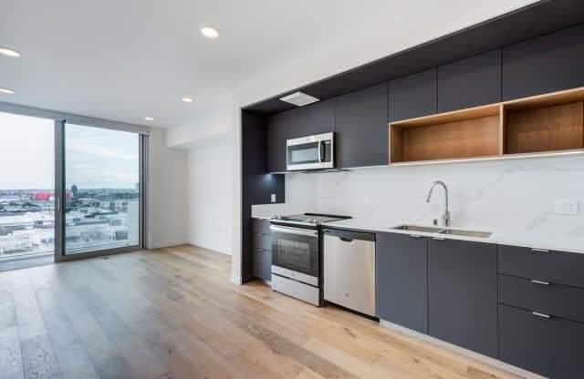 A modern kitchen with a large window overlooking a cityscape.