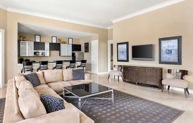 A living room with a tan couch and a glass coffee table.