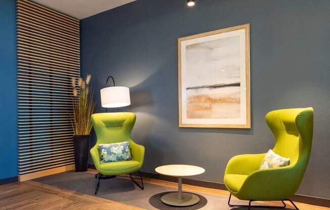 Two green chairs and a table in a room.