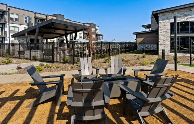 a patio with chairs and tables and a building in the background