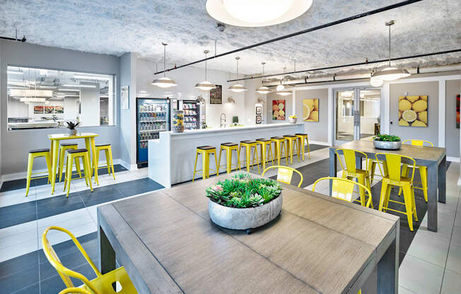 a dining room with yellow chairs and a table with a plant on it