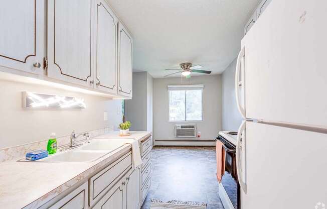 a kitchen with white cabinets and a white refrigerator