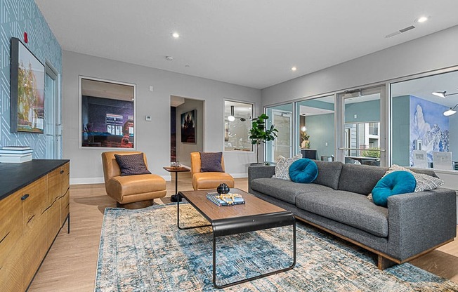 a living room with a gray couch and two orange chairs