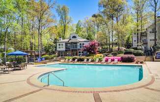 Apartments in Marietta Georgia for Rent – Wood Pointe Apartments - A large swimming pool surrounded by trees and a building in the background.
