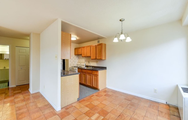 kitchen with wood cabinetry, gas range and view of dining area  at twin oaks apartments columbia heights washington dc