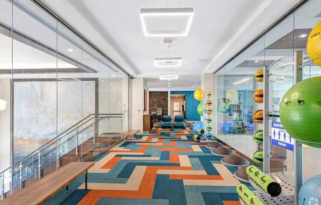 a long hallway with glass walls and a colorful carpet on the floor