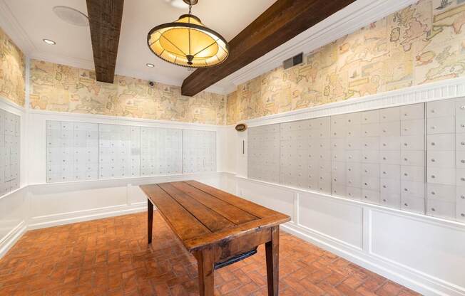 A mail room with a wooden table in the middle of a room with a map wallpaper.