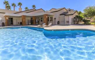 A swimming pool in front of a house.