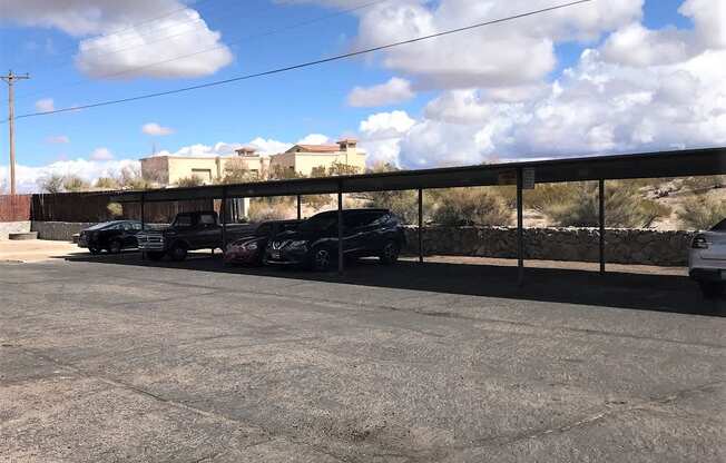 A parking lot with several cars and a building in the background.